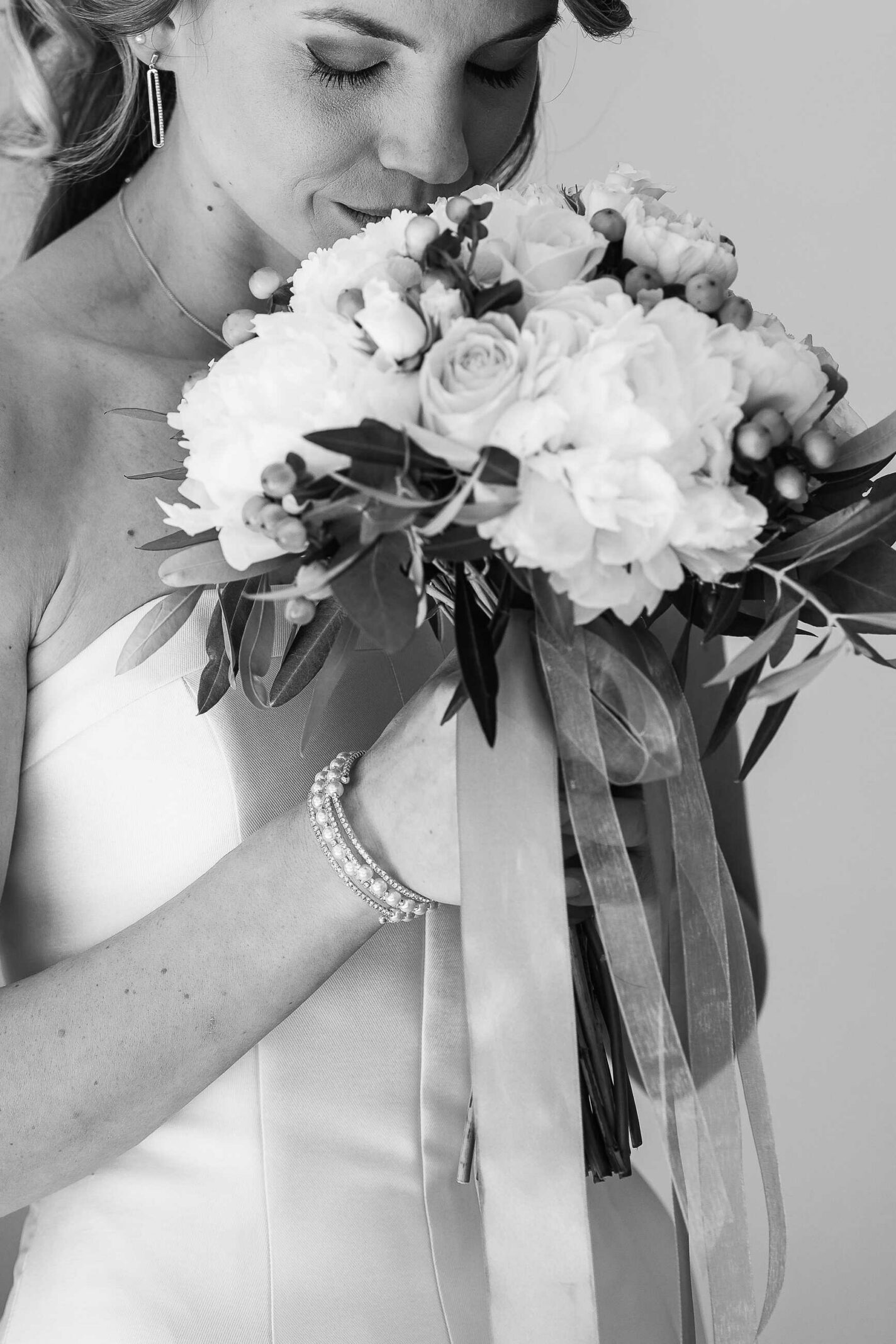 Mariée tenant son bouquet de fleurs près de son visage